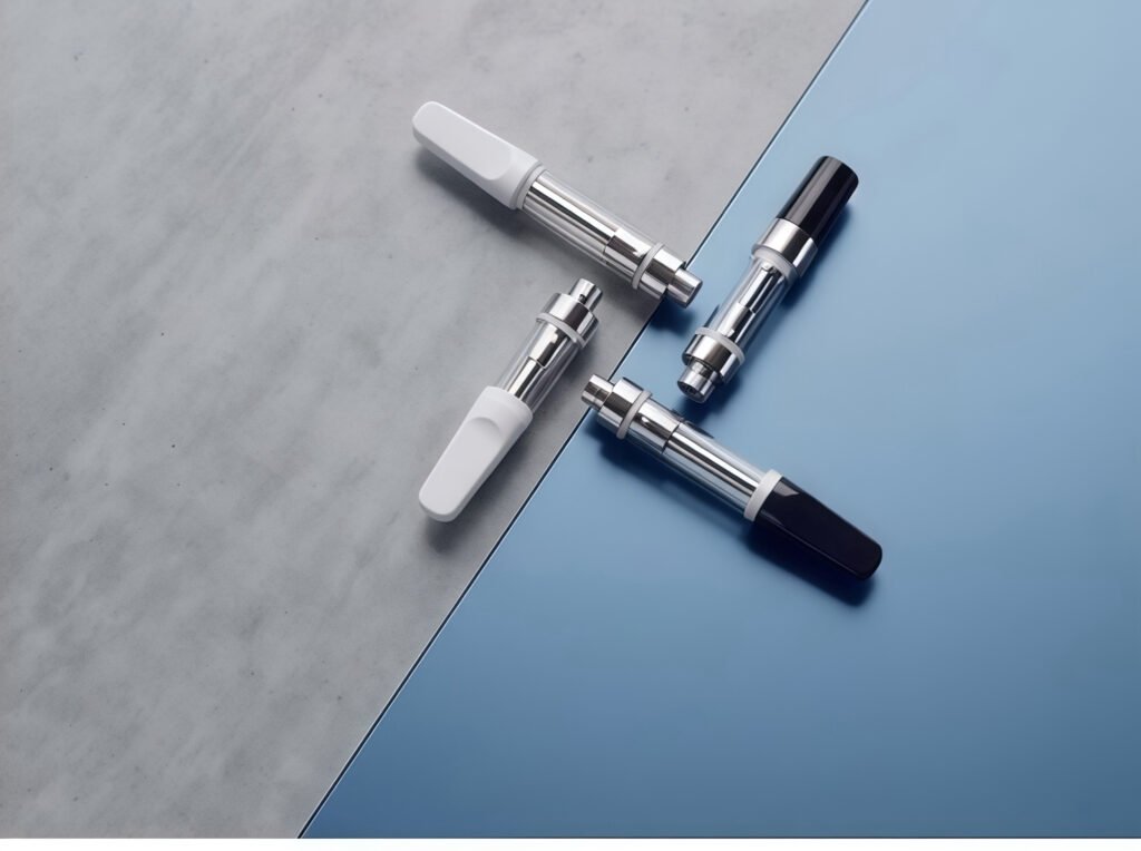 Four custom uKERA 510-thread glass oil cartridges with ceramic and stainless steel bases displayed on concrete and metallic blue platforms with white and black mouthpiece options.